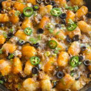 Freshly baked totchos garnished with green onions and sliced jalapenos.