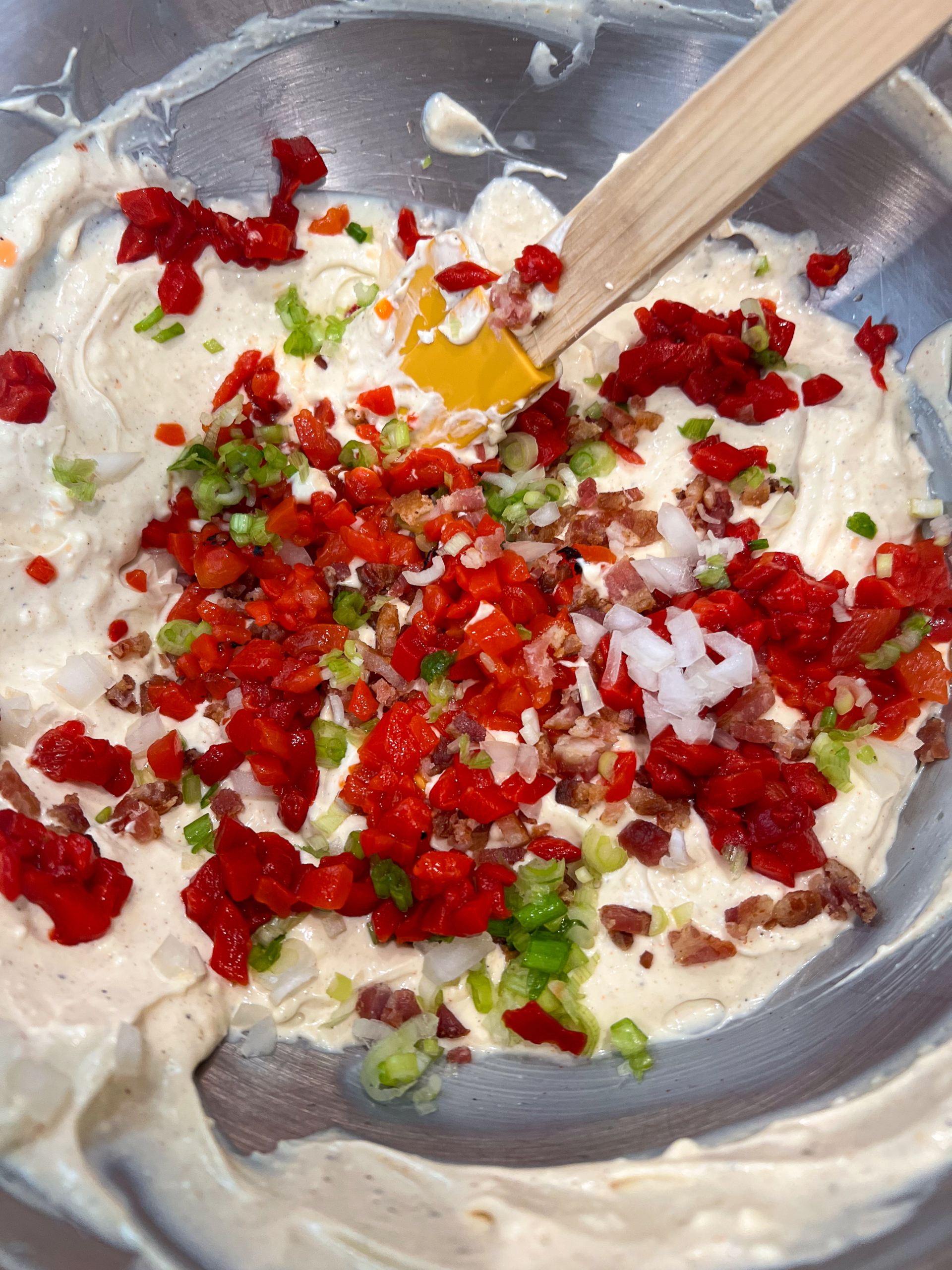 Bacon, green onions, yellow onion, roasted red pepper, and pimentos added to the creamy mixture.