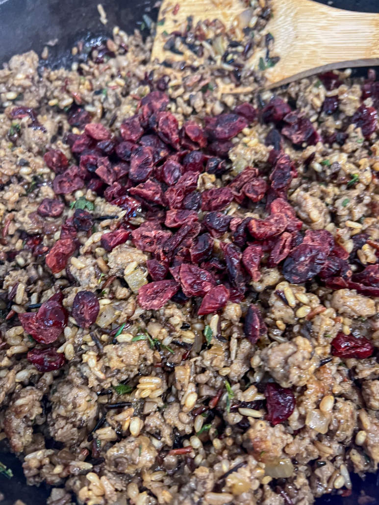 Dried cranberries being added to the stuffing mixtures.