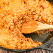 Cheeseburger bacon casserole with a portion removed in a cast iron skillet.