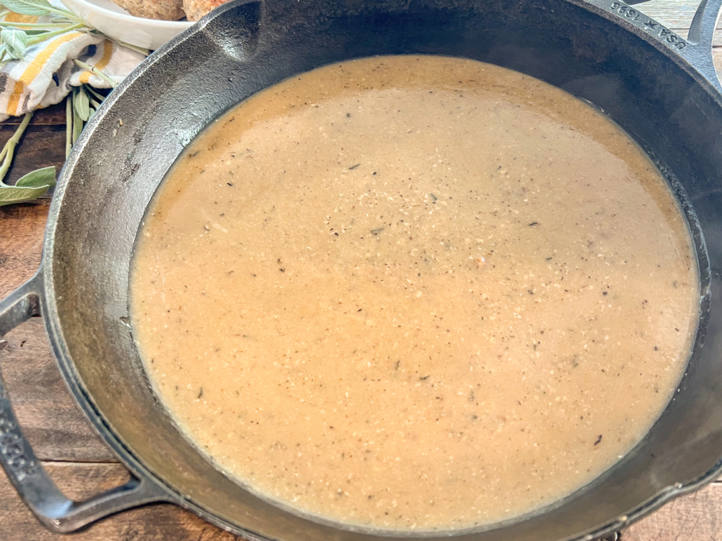 Pan gravy in a cast iron skillet is done and ready to be served.