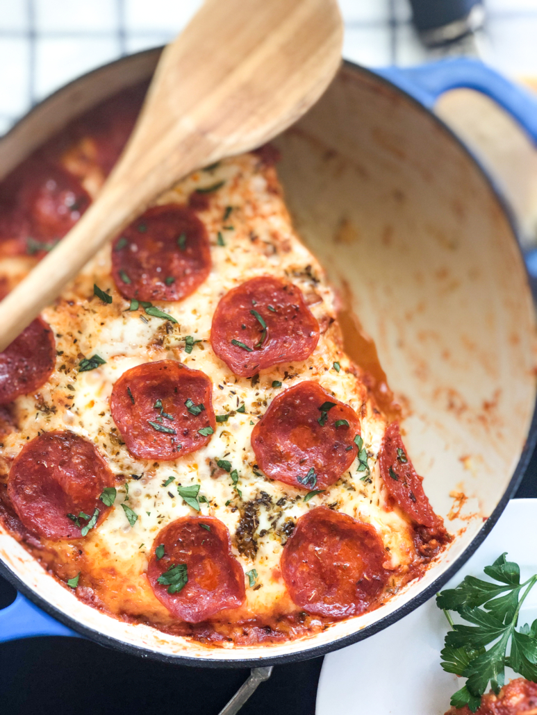 Pizza pasta in a dutch oven with a portion removed.