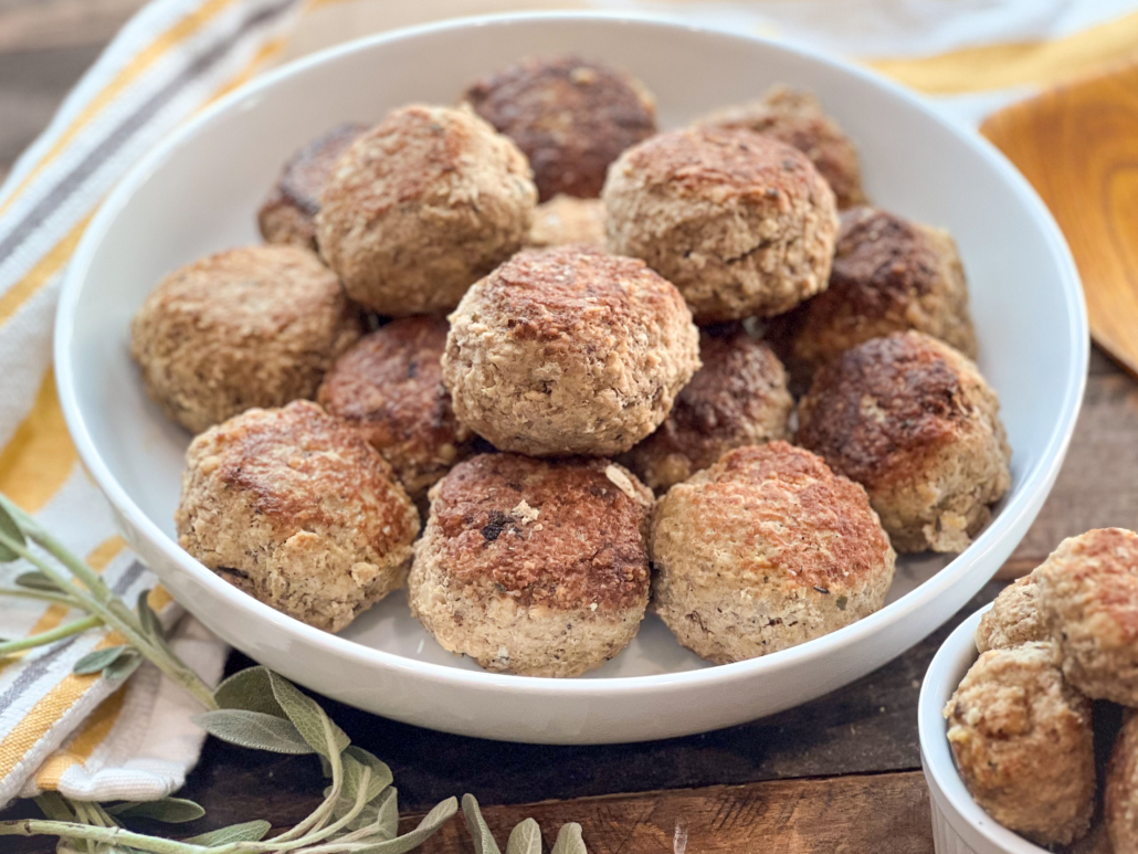 A large white serving bowl of turkey and stuffing meatballs.