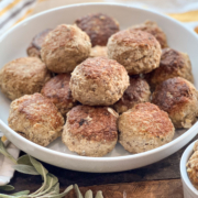 A large white serving bowl of turkey and stuffing meatballs.