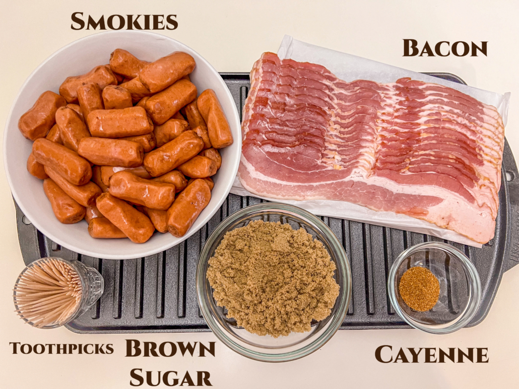 Ingredients needed for the recipe: mini smoked sausages, bacon, cayenne, brown sugar, and toothpicks resting on a cast iron grill pan.