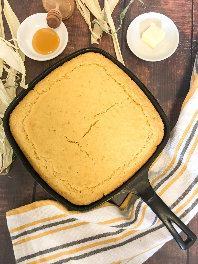 Creamed corn cornbread in a square cast iron skillet on a table.