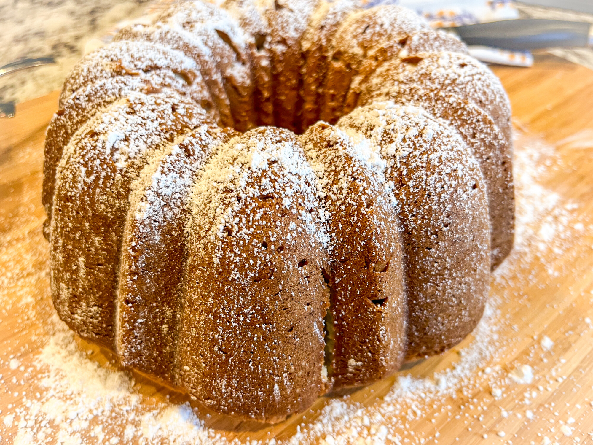 White almond cake dusted with powdered sugar, ready for serving.
