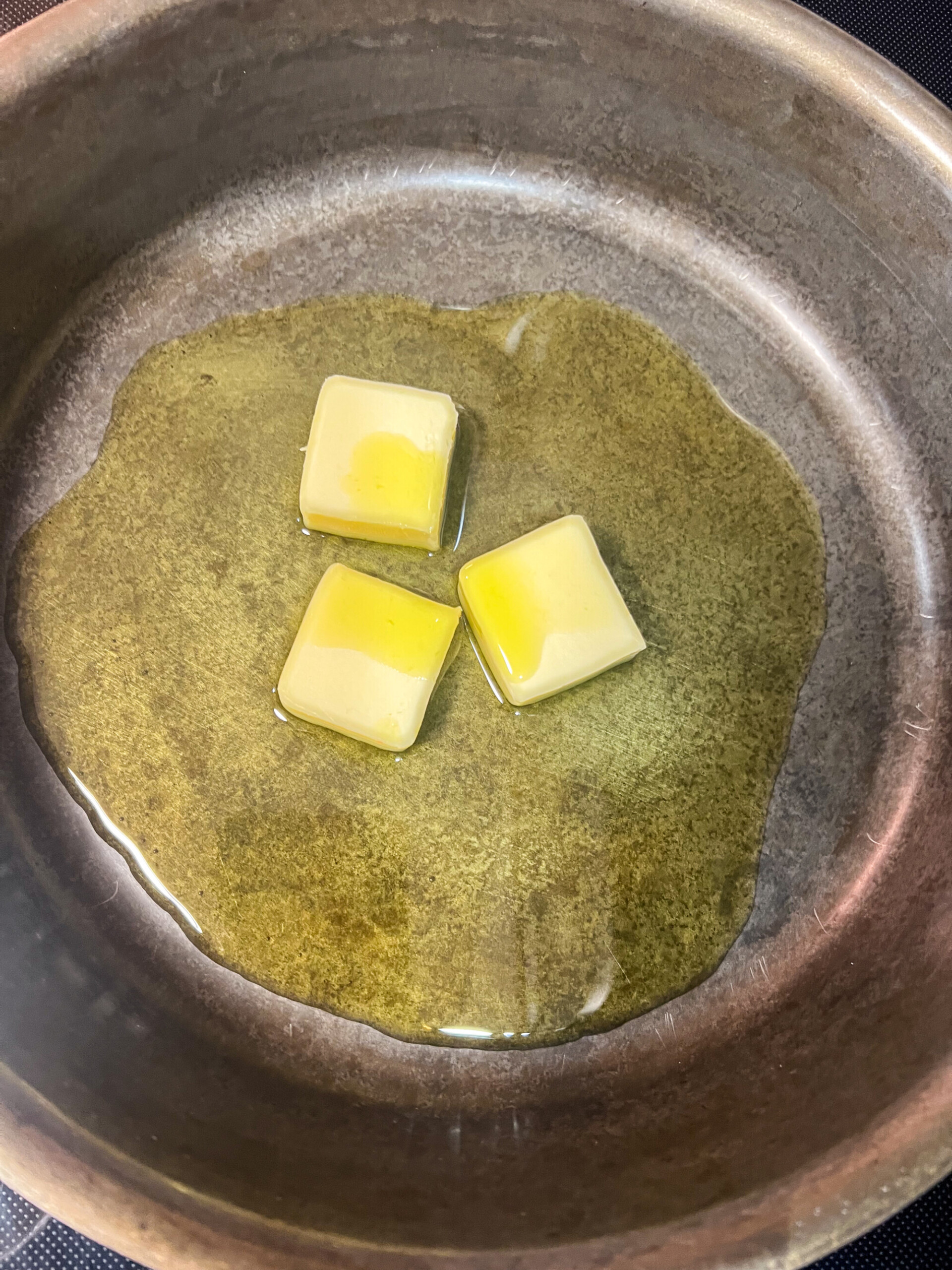 Butter and olive oil added to a cast iron skillet.