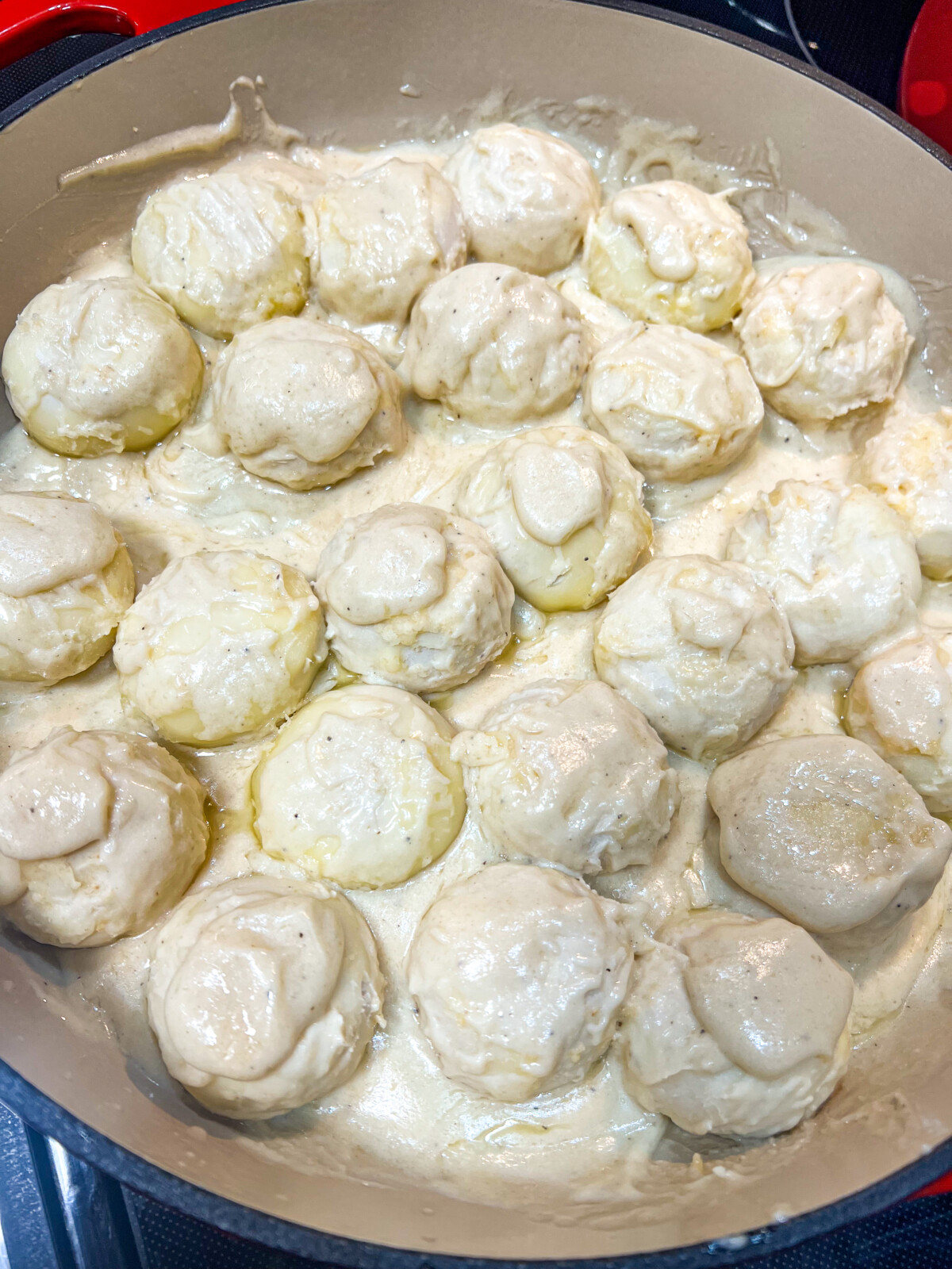 Alfredo sauce being added to the Cheesy Alfredo Pull Aparts.