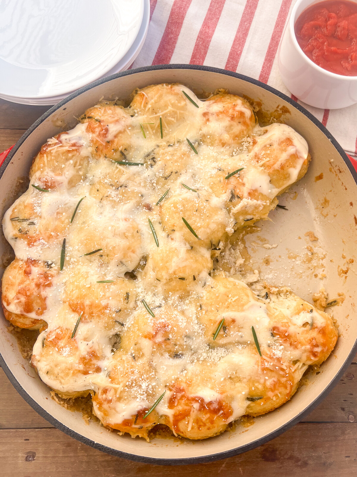 Cheesy Alfredo Pull Aparts being displayed in an uncovered Dutch Oven. Three of the pull aparts have been already served.