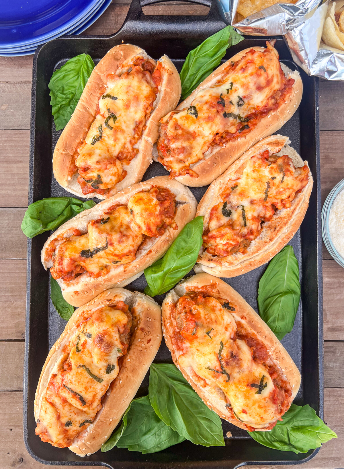 Cast iron baking sheet with six toasted meatballs subs.