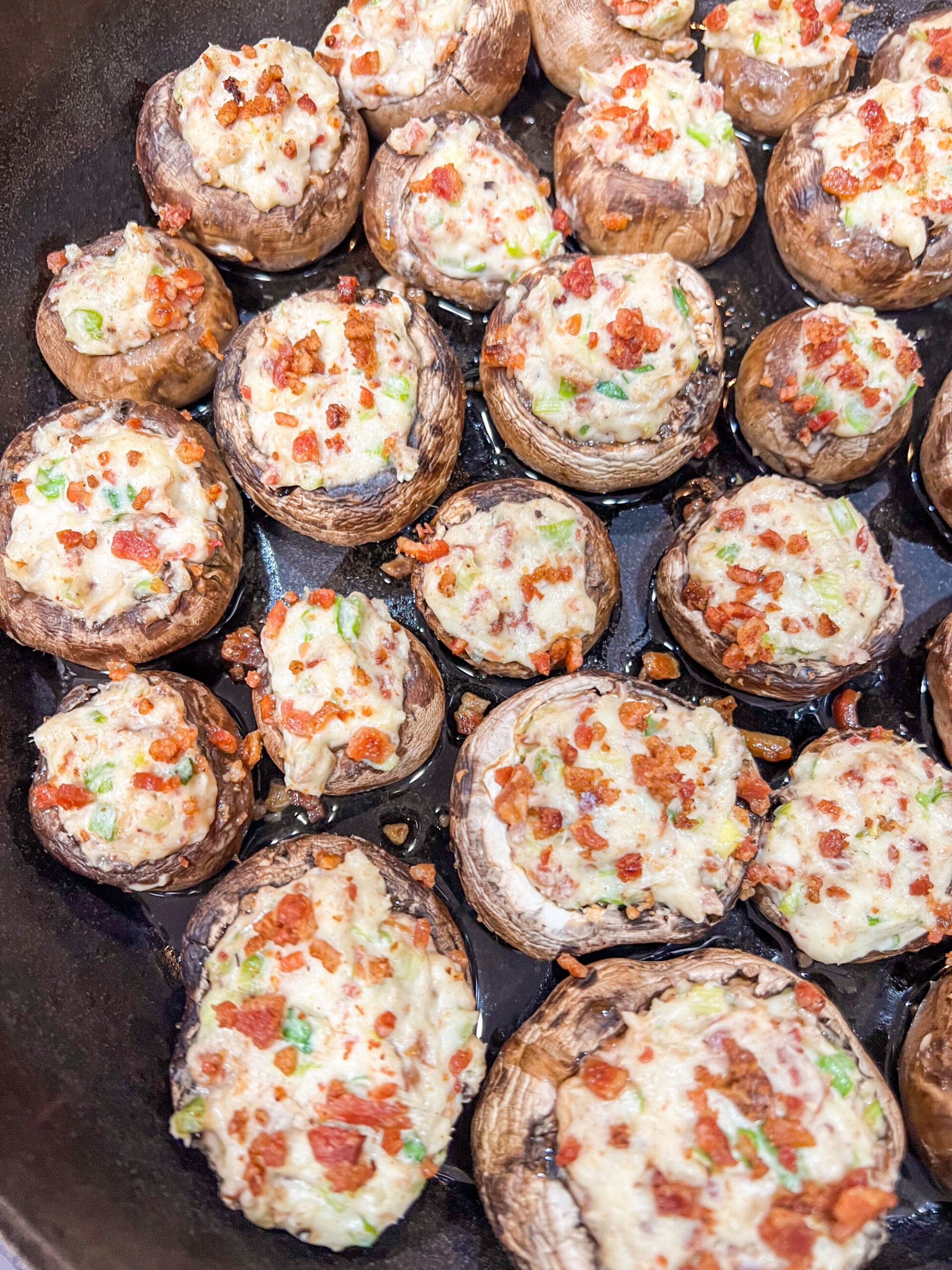 Cream cheese stuffed mushrooms in a 12" camping Dutch Oven topped with remaining bacon. 