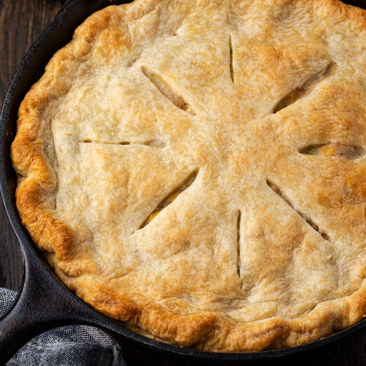 A skillet chicken pot pie after baking on the table ready to eat.