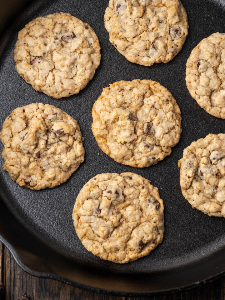 A cast iron skillet full of soft and chewy oatmeal chocolate chip cookies.