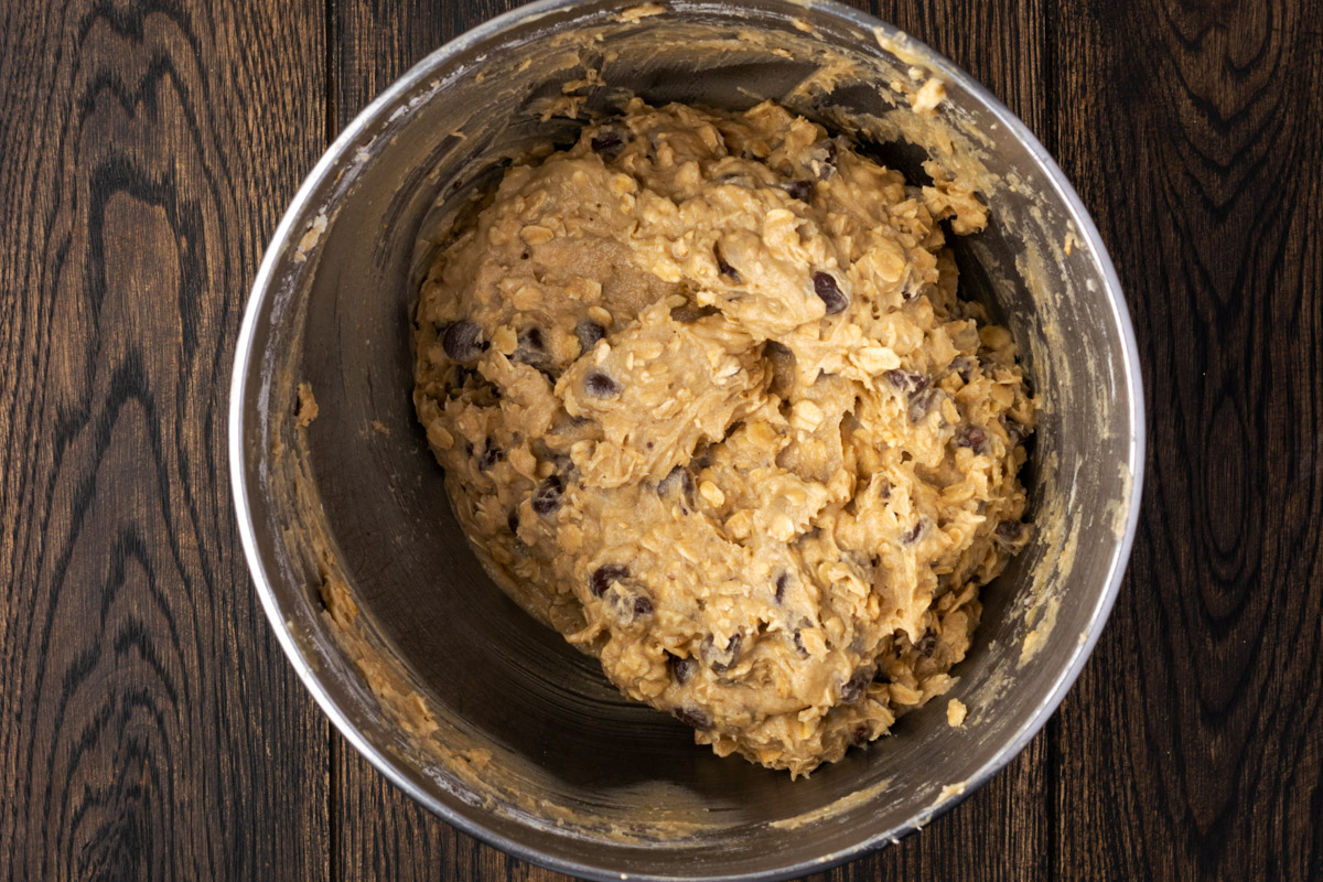 mixed ingredients for oatmeal chocolate chip cookies ready to spoon on a cast iron skillet.