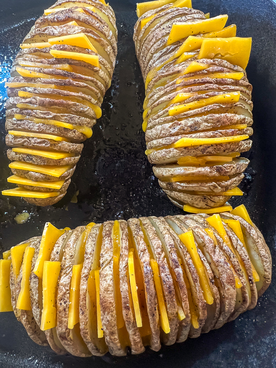 Slices of deli-style cheddar cheese placed between each sliced layer of potato.