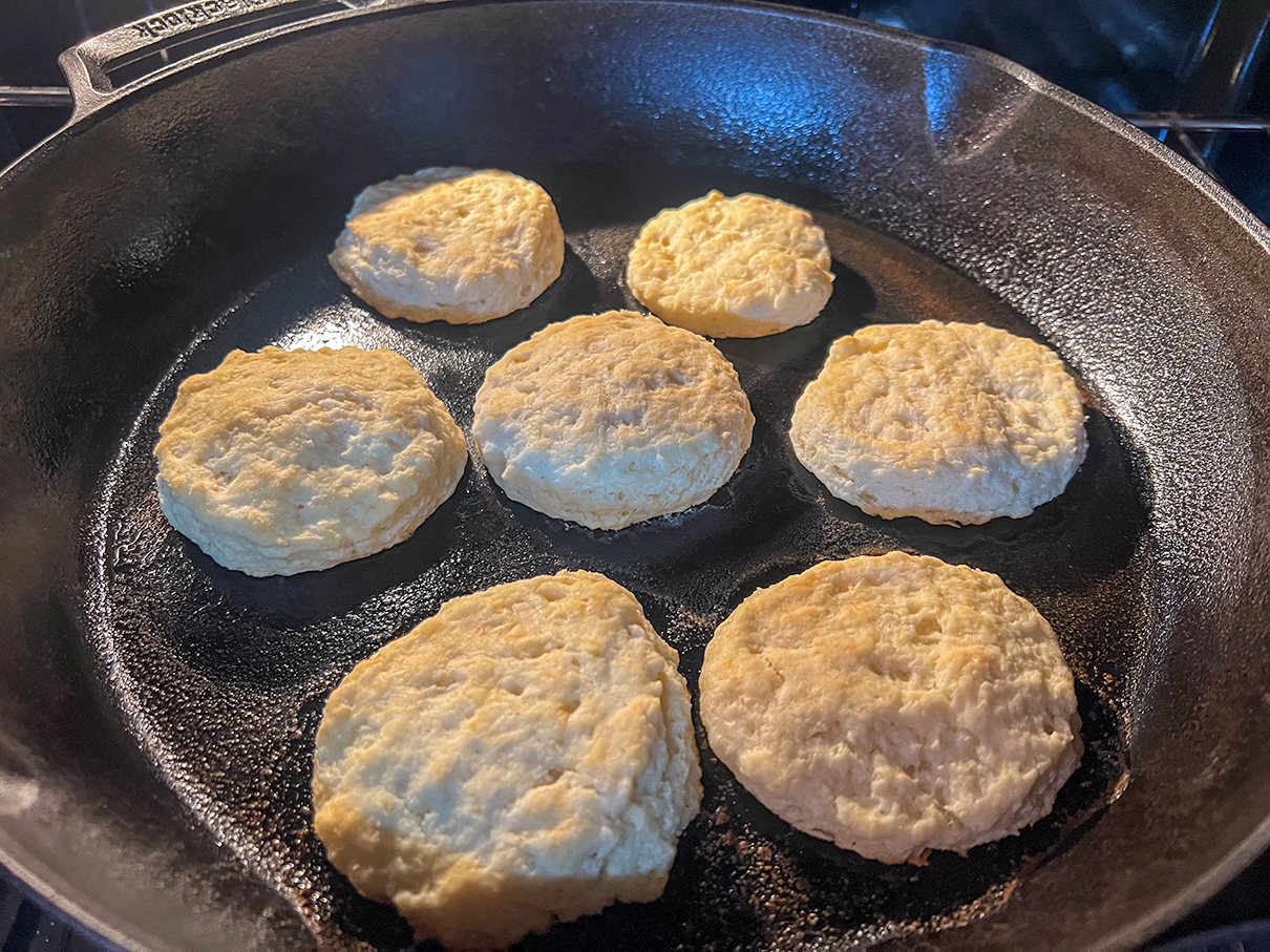 Biscuits in a skillet baking in the oven.