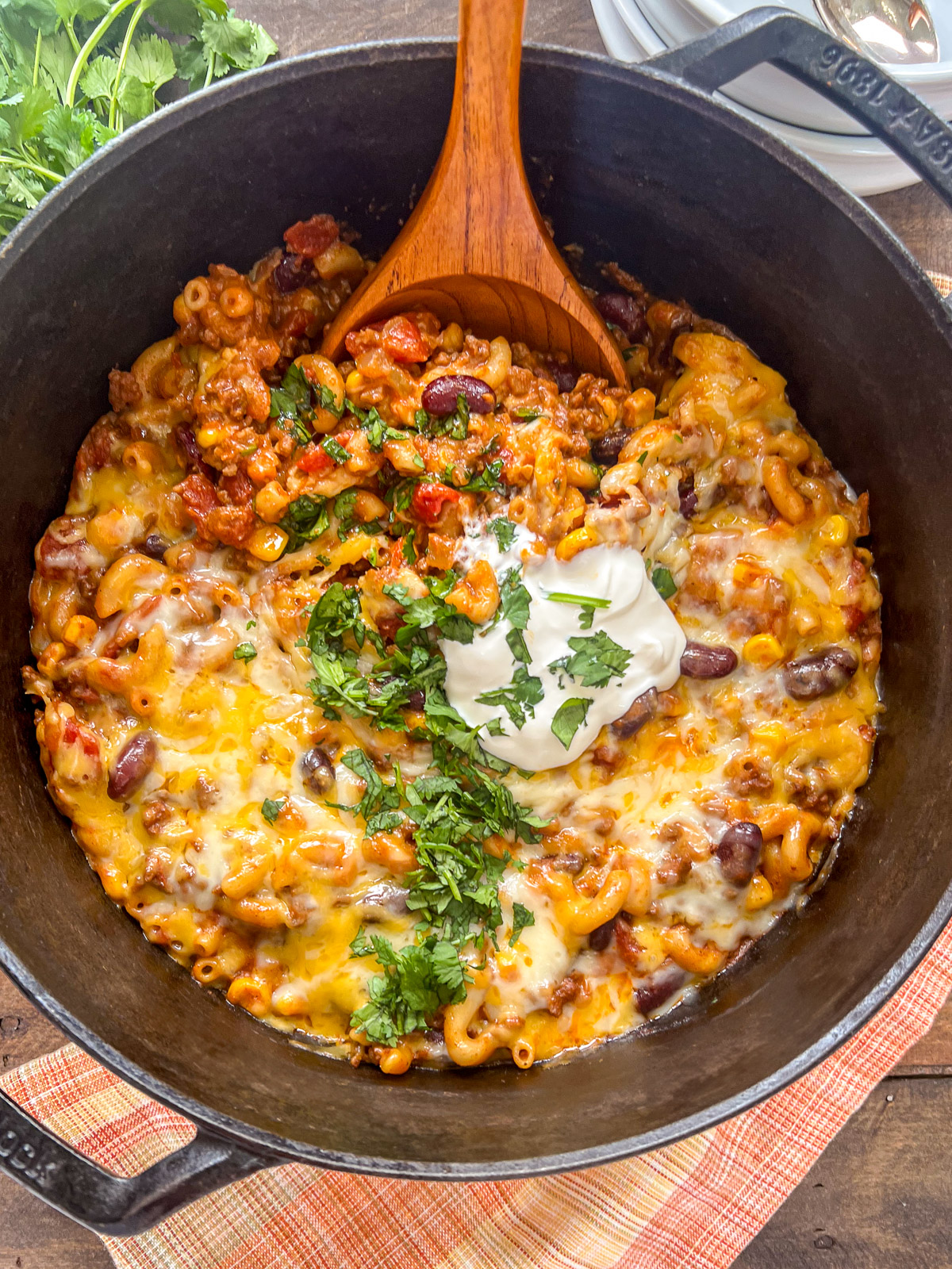 A wooden ladle starting to lift a serving of the recipe in the dutch oven.