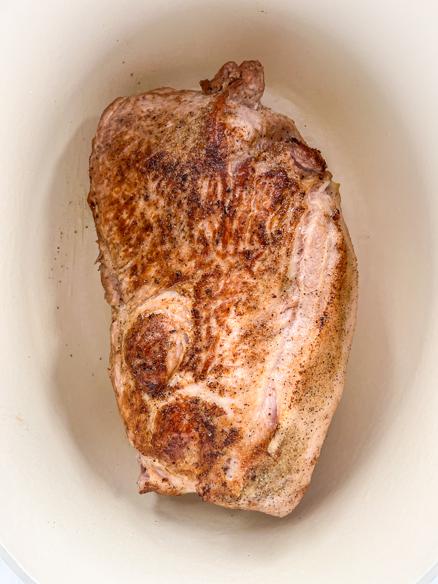 Pork roast has been seared in the dutch oven.