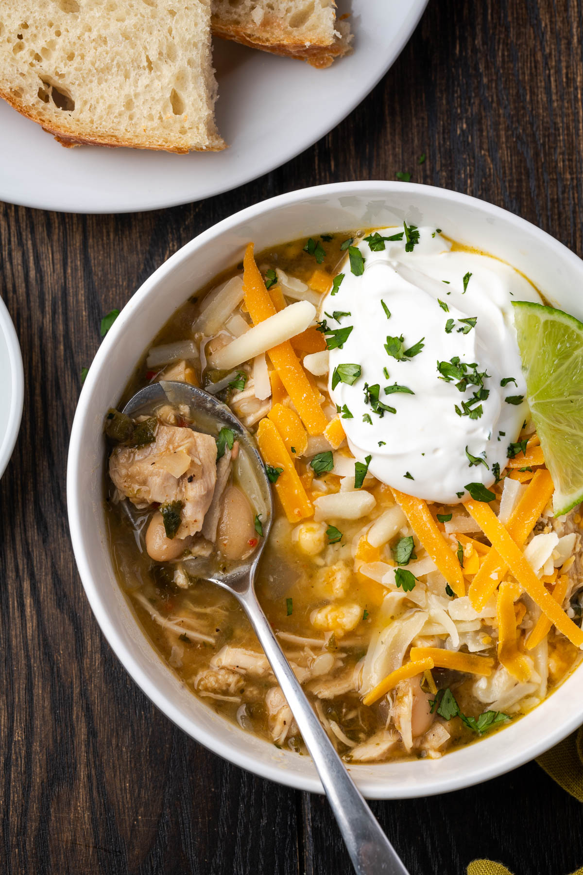 A bowl of chili topped with cheese and sour cream.