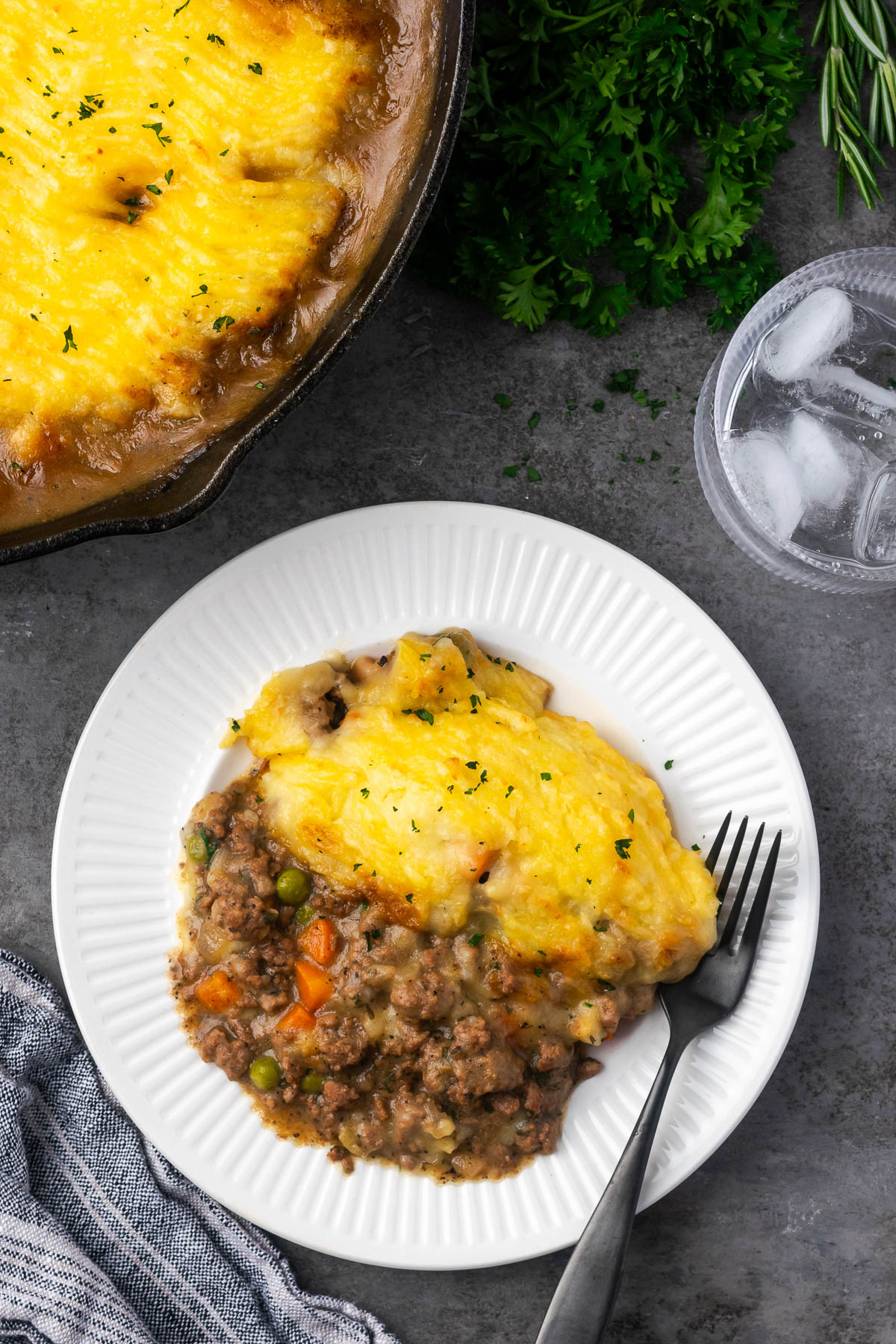 A serving of skillet shepherd's pie on a white plate with a fork to the side.