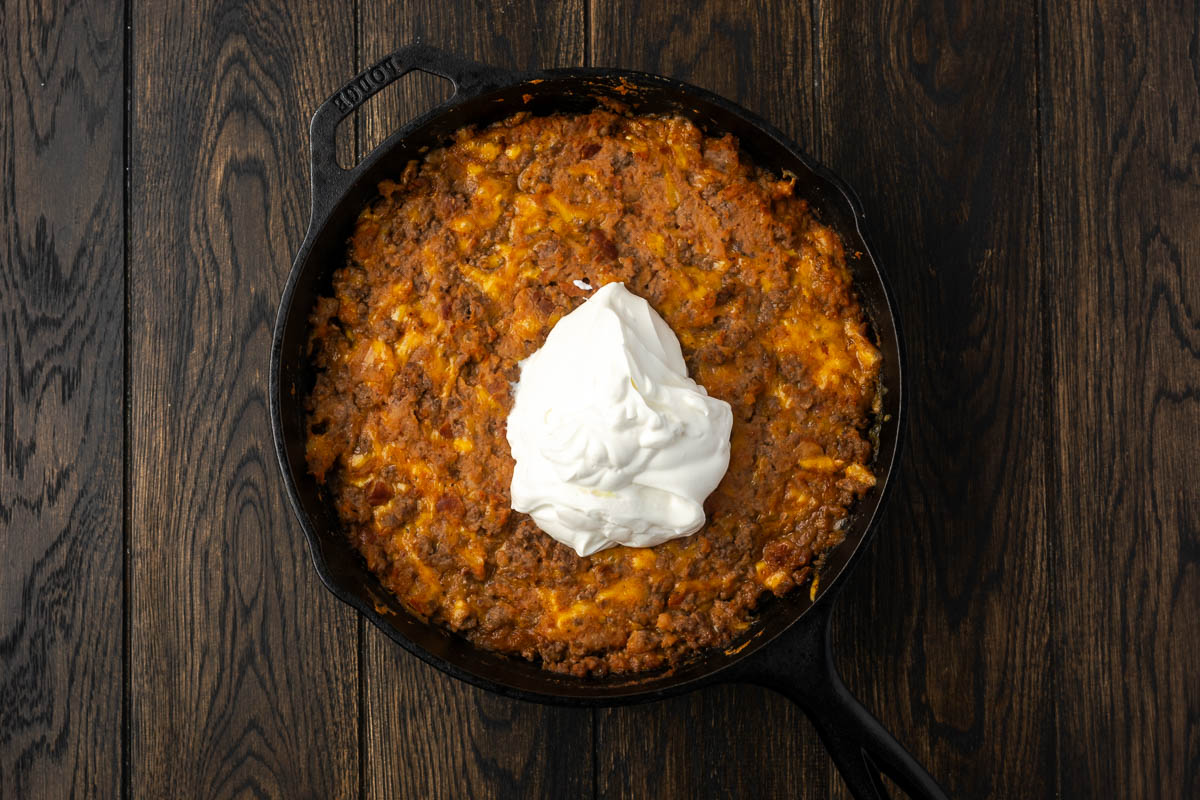Sour cream added on top of the beef and bean mixture.