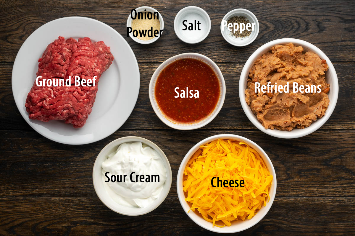 Ingredients to make nacho refried bean dip on the table before preparing.