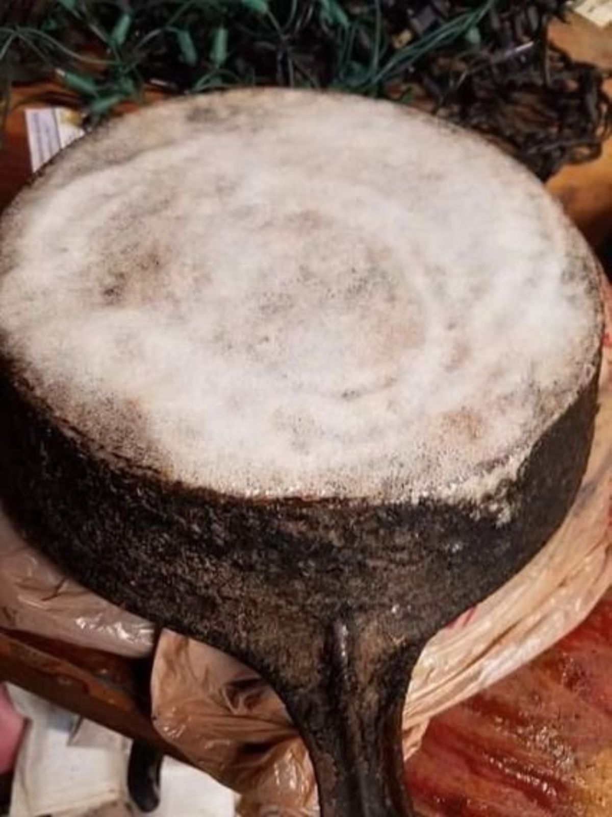 A cast iron skillet upside down to show stripping the cast iron skillet with oven cleaner.