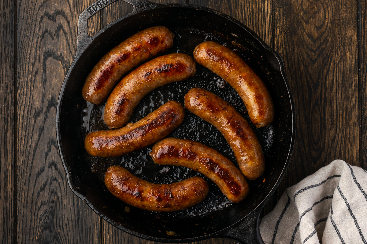 Seared beer brats in the skillet.