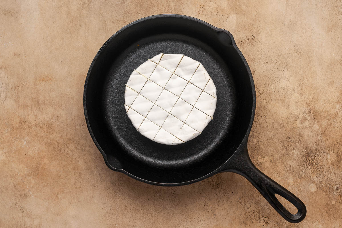 Brie in a skillet with the top scored. 