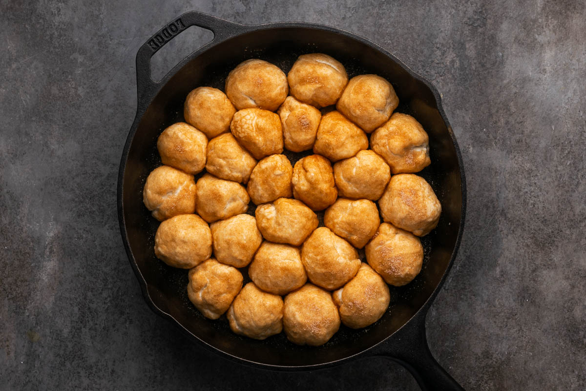Dough balls arranged in a skillet.