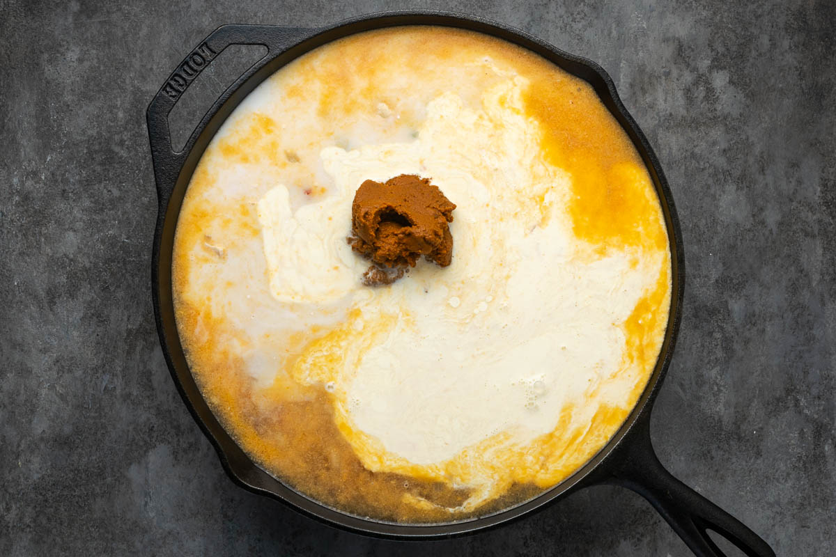 Coconut milk and curry paste added to the skillet.