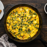 Spinach fritatta cooked in a skillet.