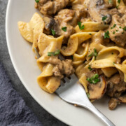 A plate of ground turkey stroganoff with a fork resting to the side.