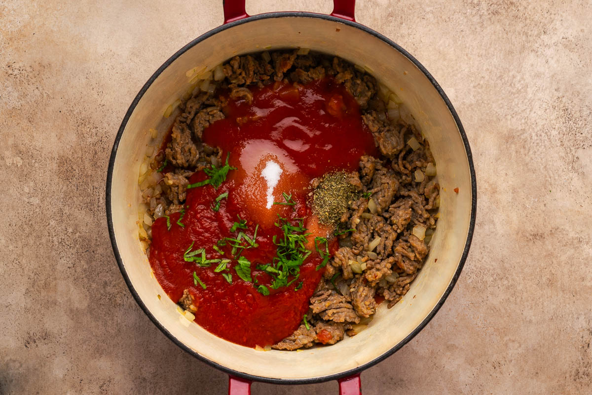 Sauce ingredients added to the browned meat and vegetables.