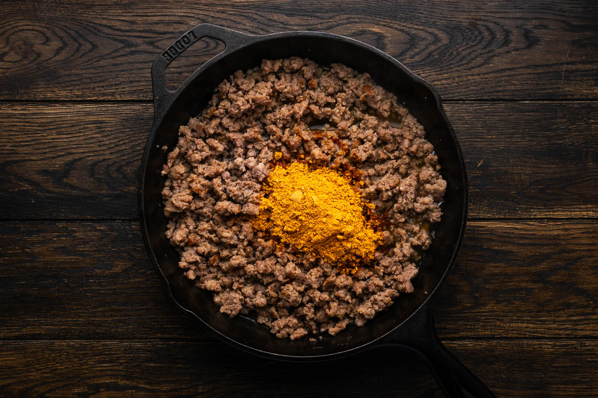 Adding the taco seasoning to the sausage. 