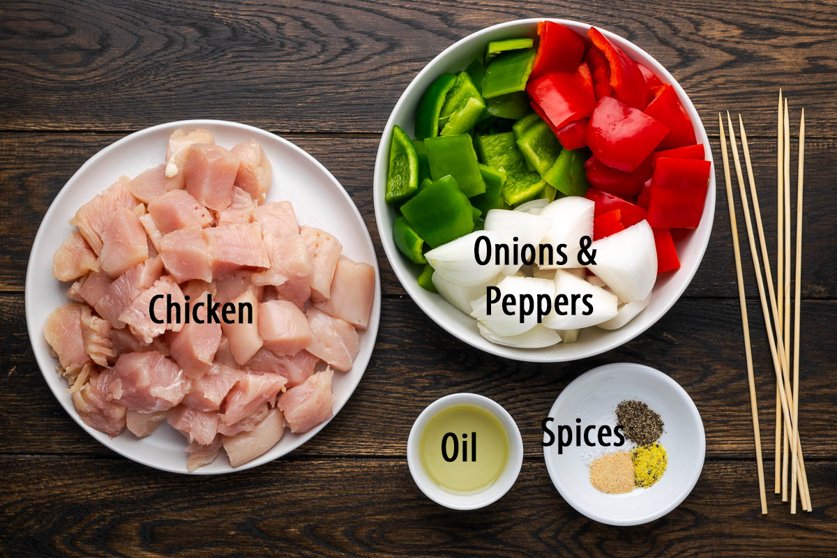Ingredients to make chicken kabobs labeled to identify them.