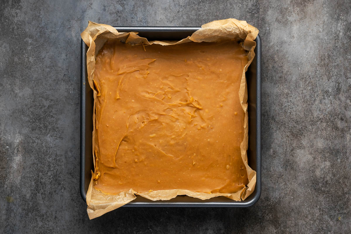 Peanut butter fudge poured into a square pan to set.