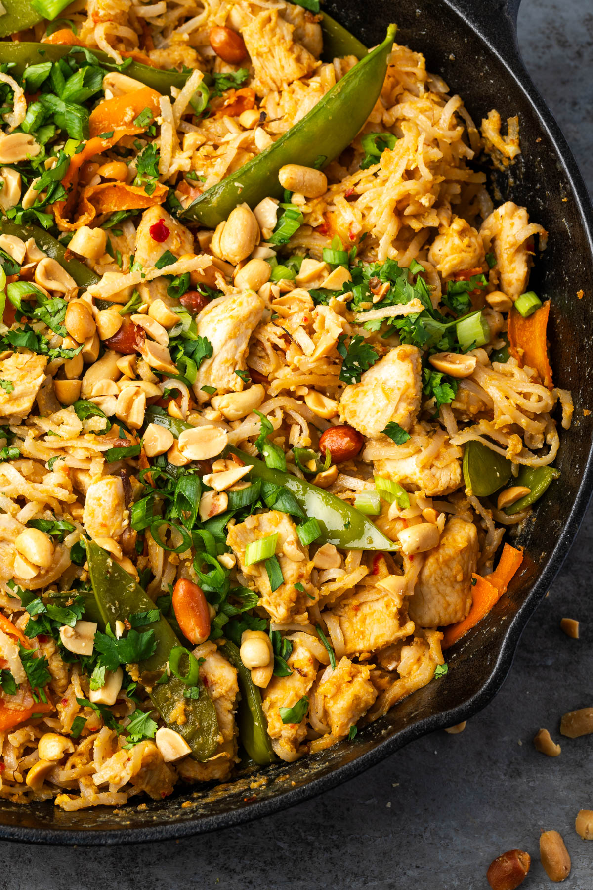 A cast iron skillet of peanut chicken stir fry ready to serve. 