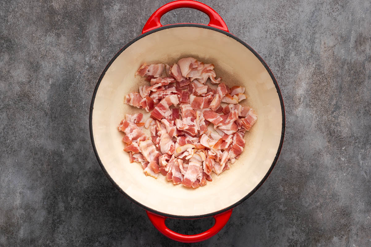 Bacon cooking in a Dutch oven.