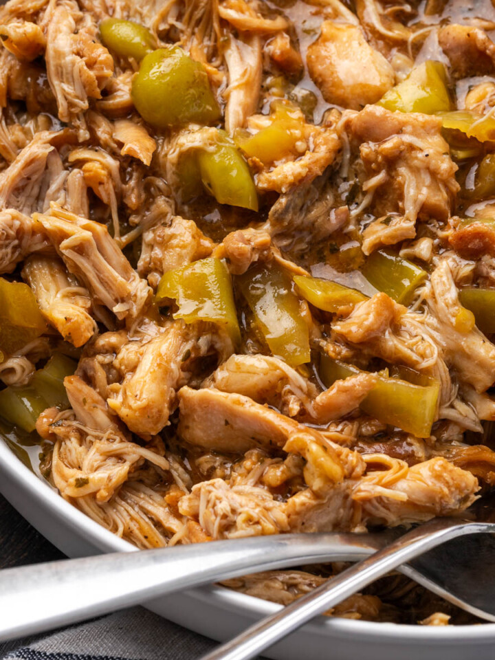 Mississippi chicken in a bowl with spoons resting to the side.