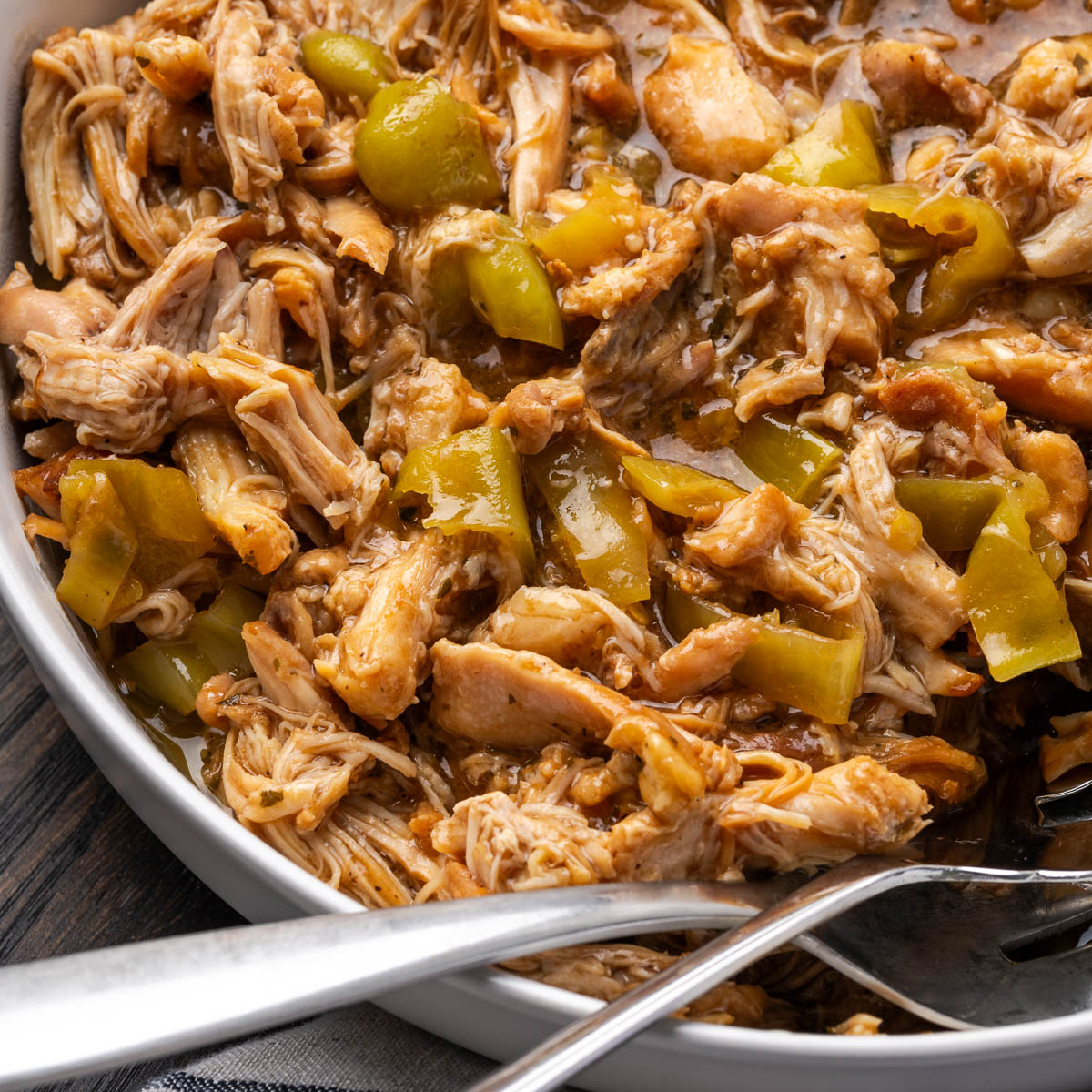 Mississippi chicken in a bowl with spoons resting to the side.