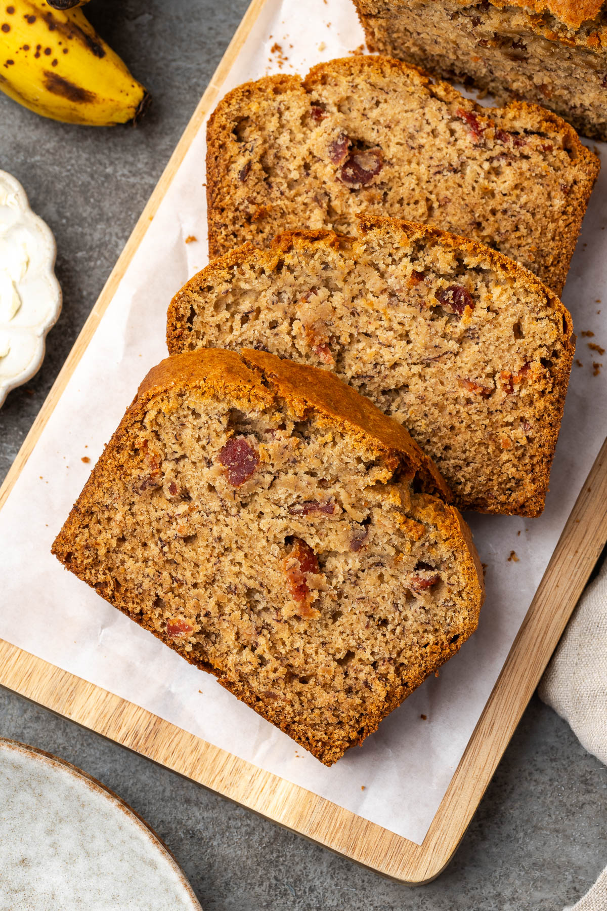 A loaf of bacon banana bread sliced on a platter.