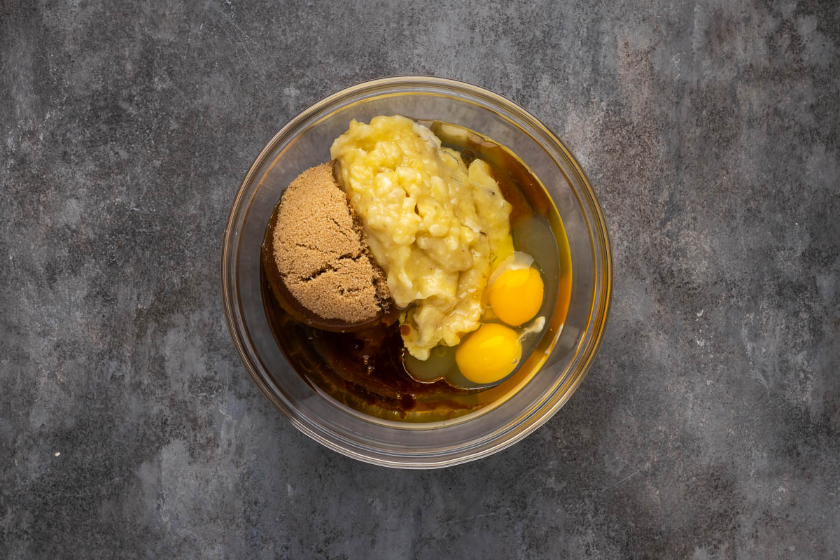 Egg, sugar, and banana in a mixing bowl.