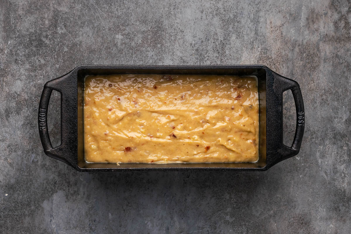 Poured banana bread batter in a loaf pan.
