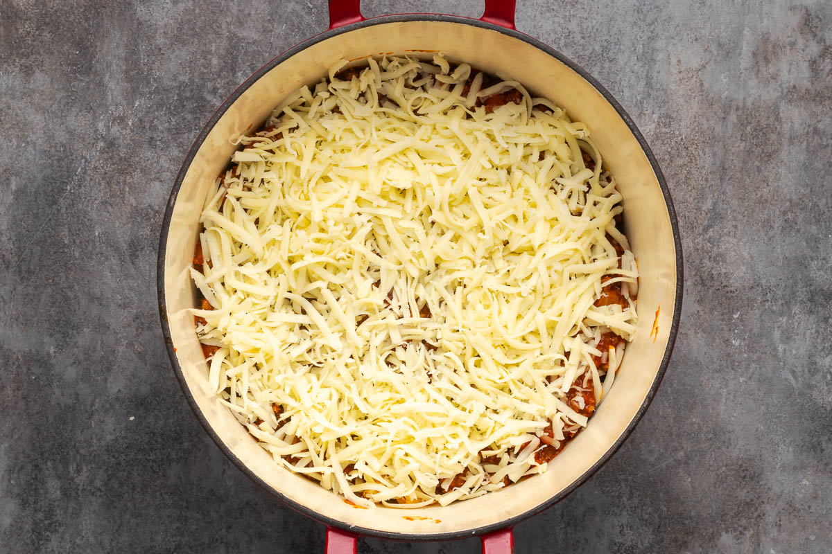 A layer of meat sauce and cheese on top.