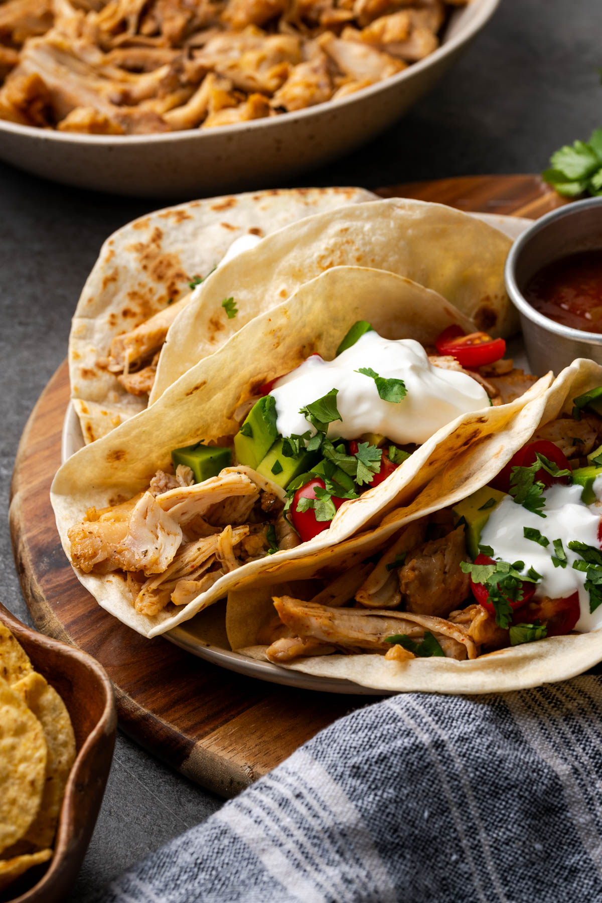 Southwest chicken served inside of a tortilla shell topped with tomatoes, avocado, salsa, sour cream, and fresh cilantro.
