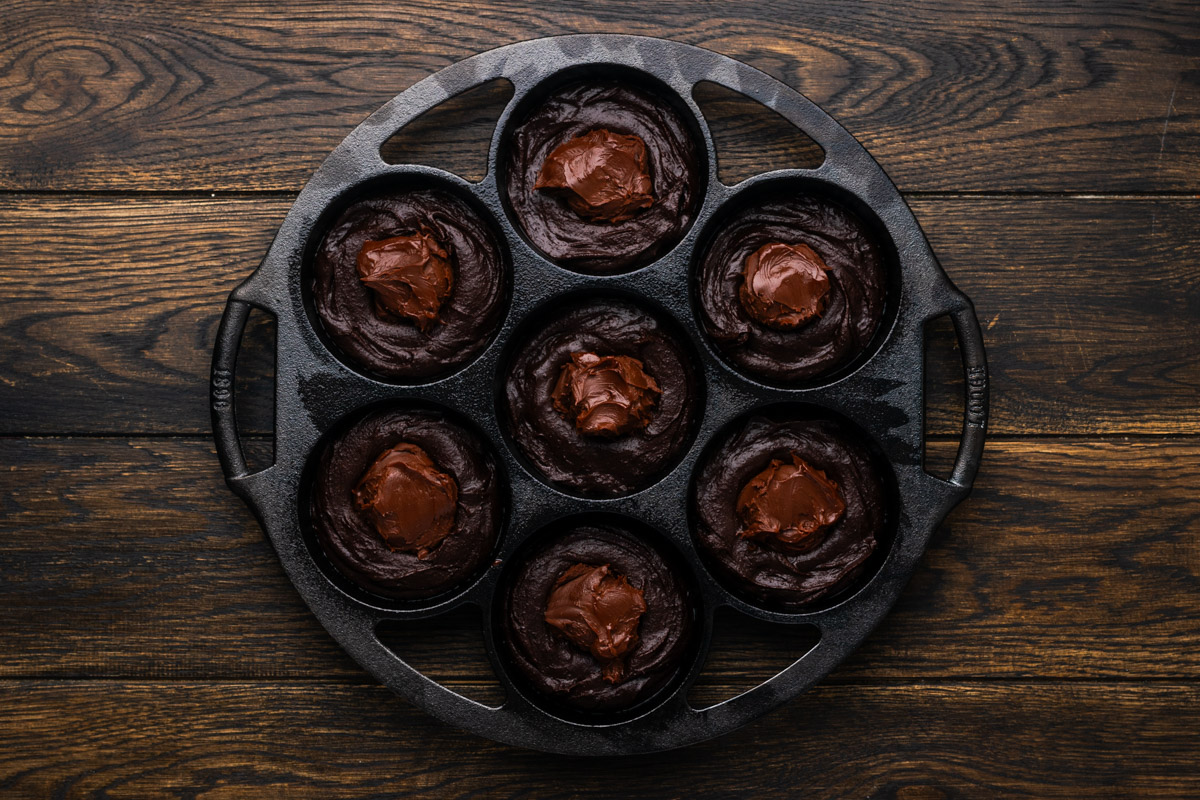 Brownie batter scooped into each mini skillet.
