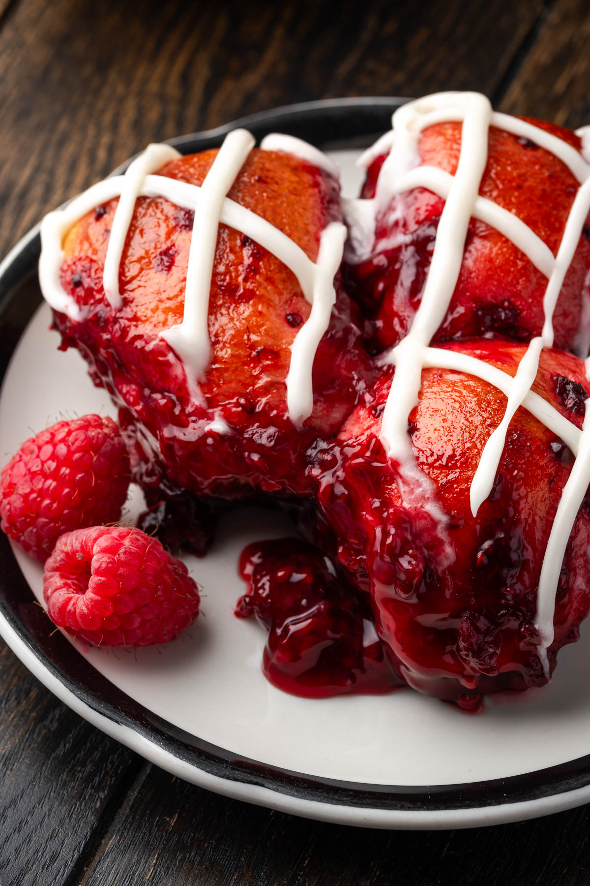 Bread with raspberries and icing on a plate.