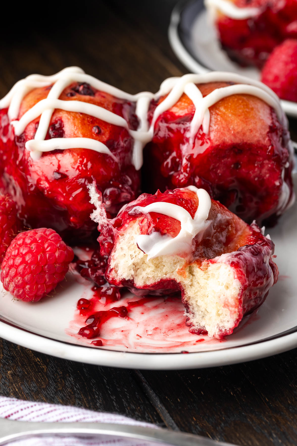 A bite taken out of the bread with raspberries.